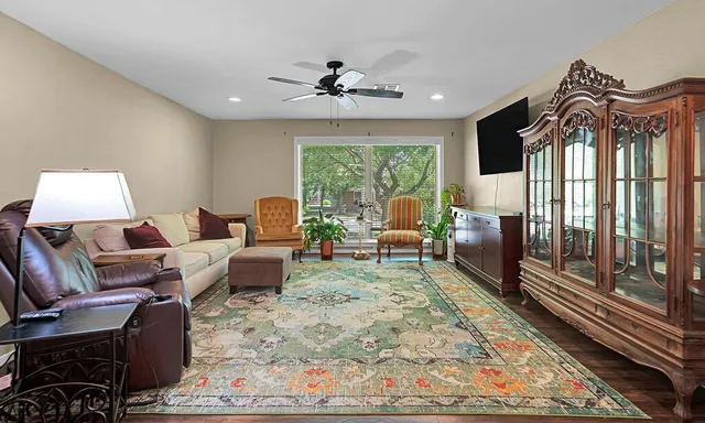 a living room with furniture floor to ceiling window and a rug