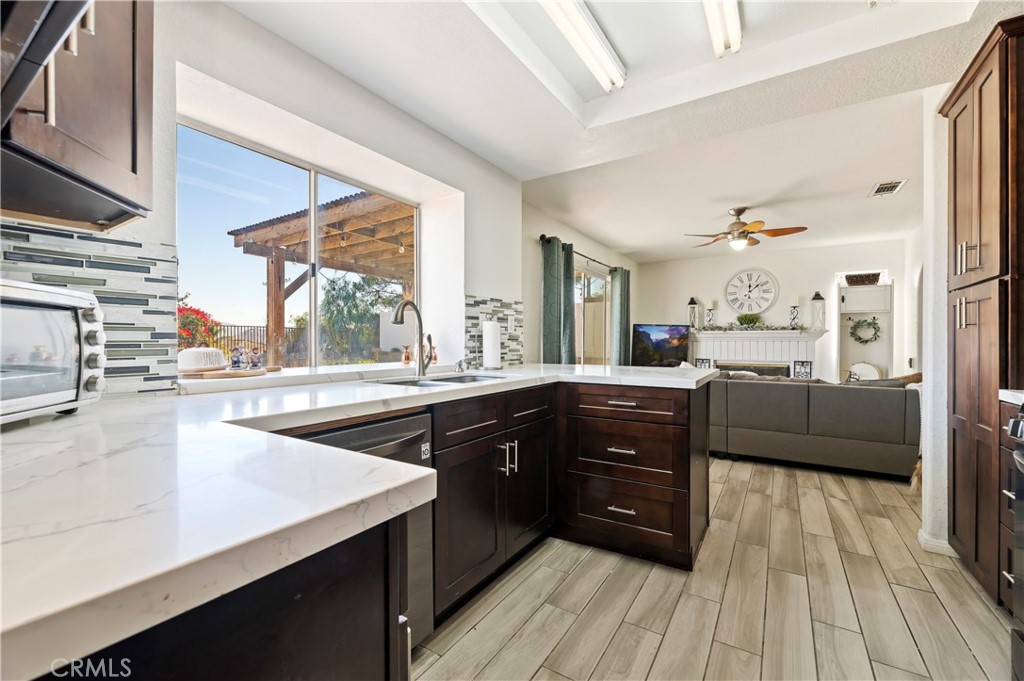 4144 Shellicia Circle Riverside, CA 92509 - Photo 11 of 33 a kitchen with a sink stove and wooden cabinets