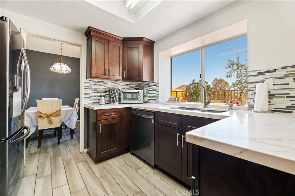 4144 Shellicia Circle Riverside, CA 92509 - Photo 14 of 33 a kitchen with a sink and a refrigerator