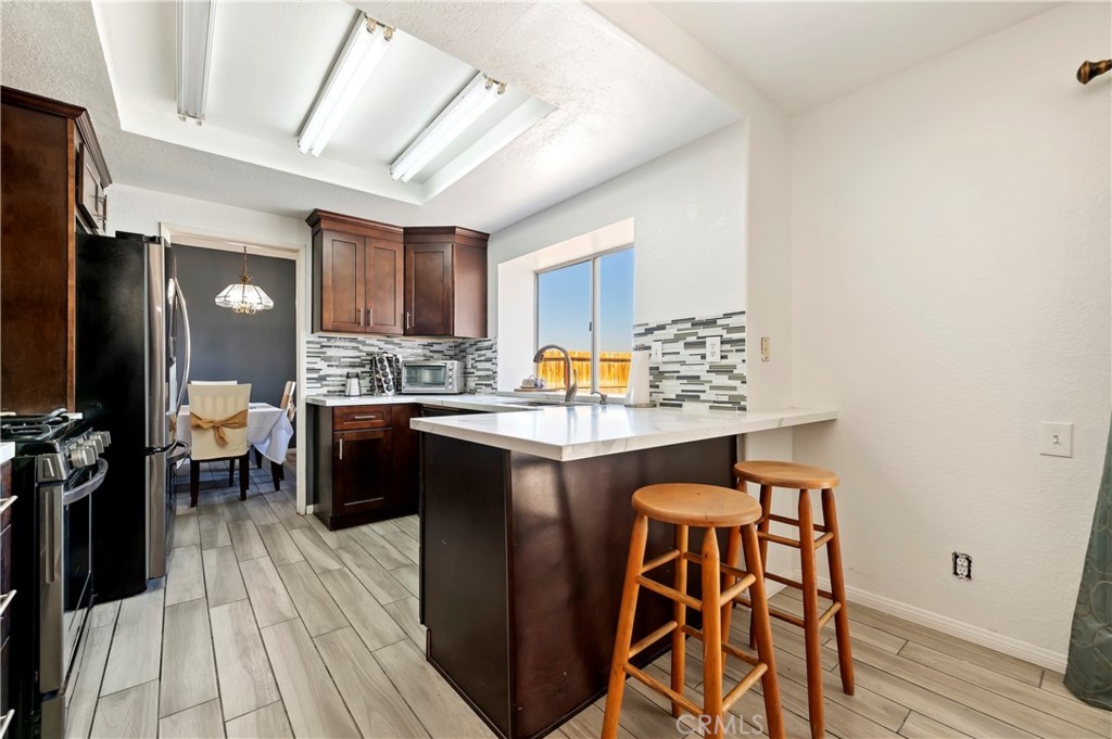 4144 Shellicia Circle Riverside, CA 92509 - Photo 15 of 33 a kitchen with a table chairs refrigerator and cabinets