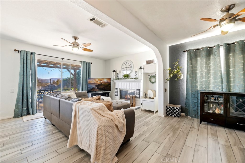 4144 Shellicia Circle Riverside, CA 92509 - Photo 19 of 33 a living room with furniture a fireplace and a flat screen tv