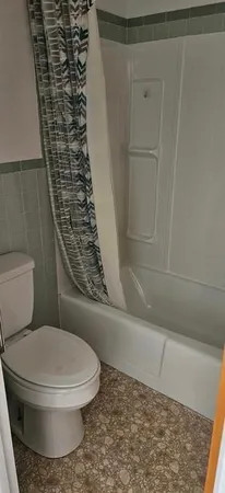 a bathroom with a toilet and a shower