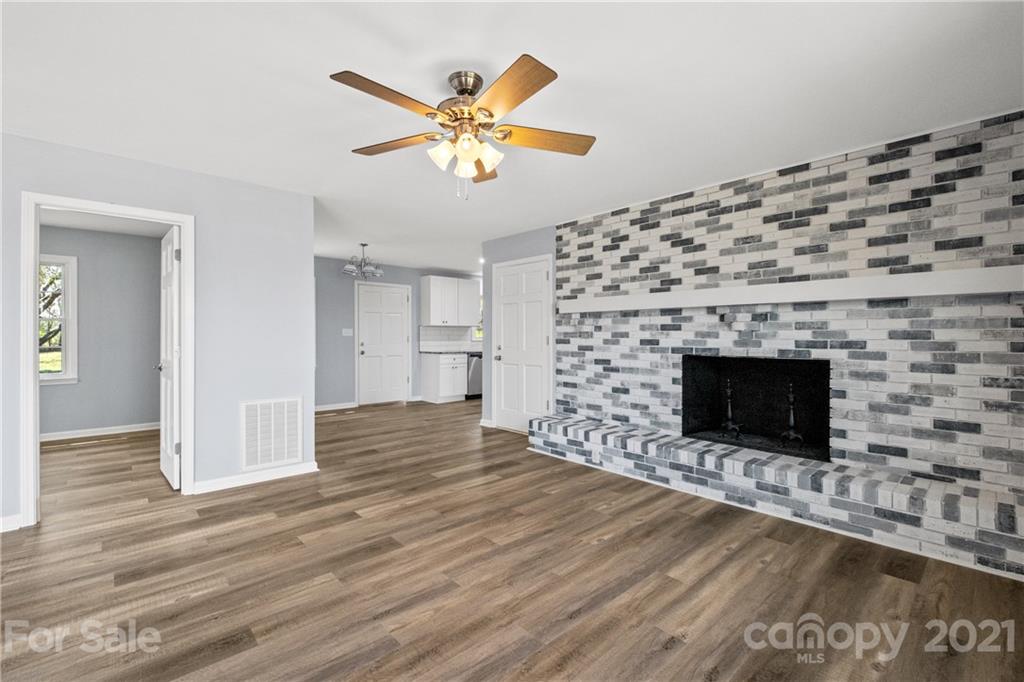955 Potneck Road Salisbury, NC 28147 - Photo 8 of 28 a view of an empty room with wooden floor and a fireplace