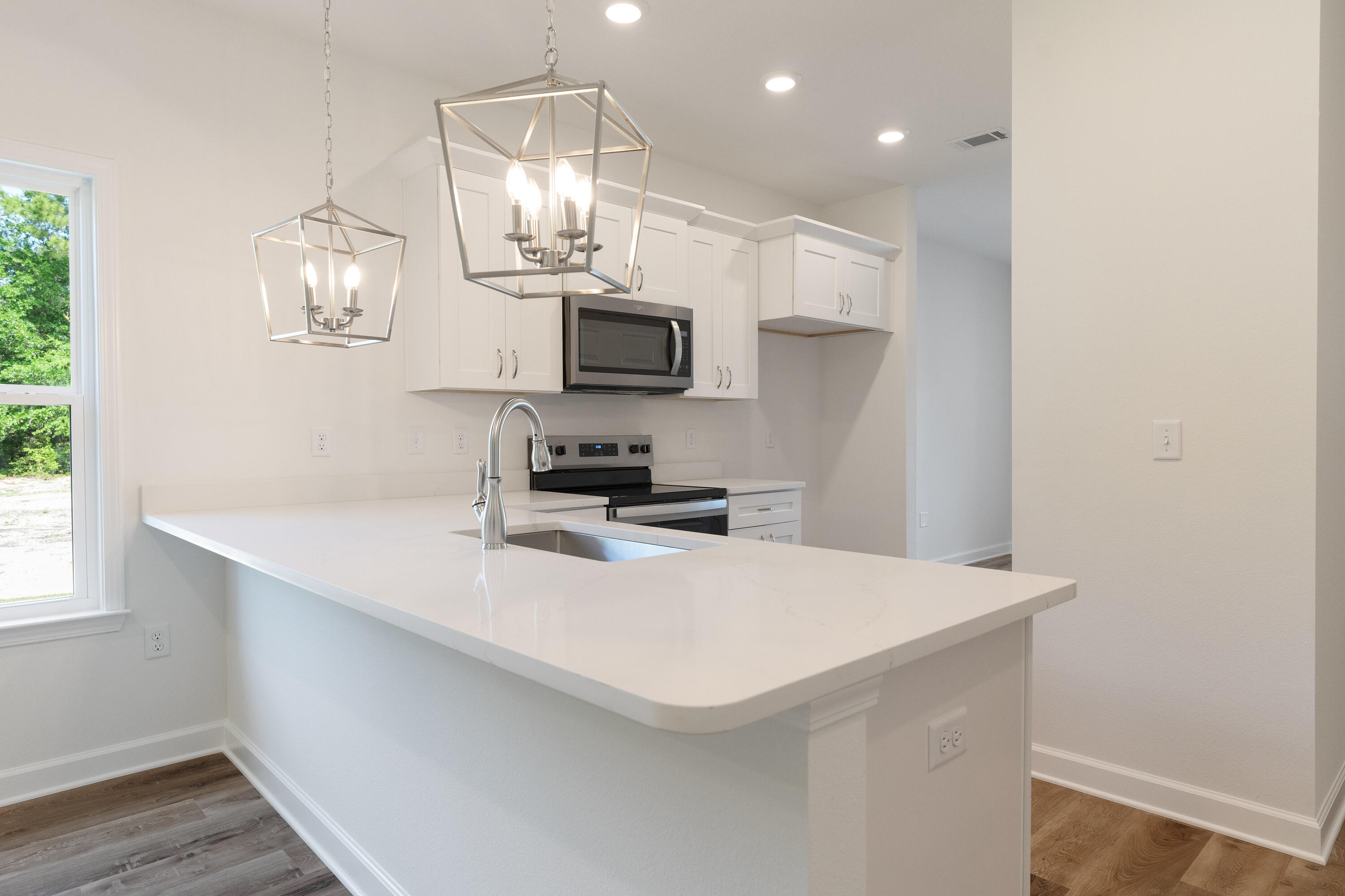 3202 Oxmore Drive Crestview, FL 32539 - Photo 6 of 20 a kitchen with kitchen island white cabinets and stainless steel appliances