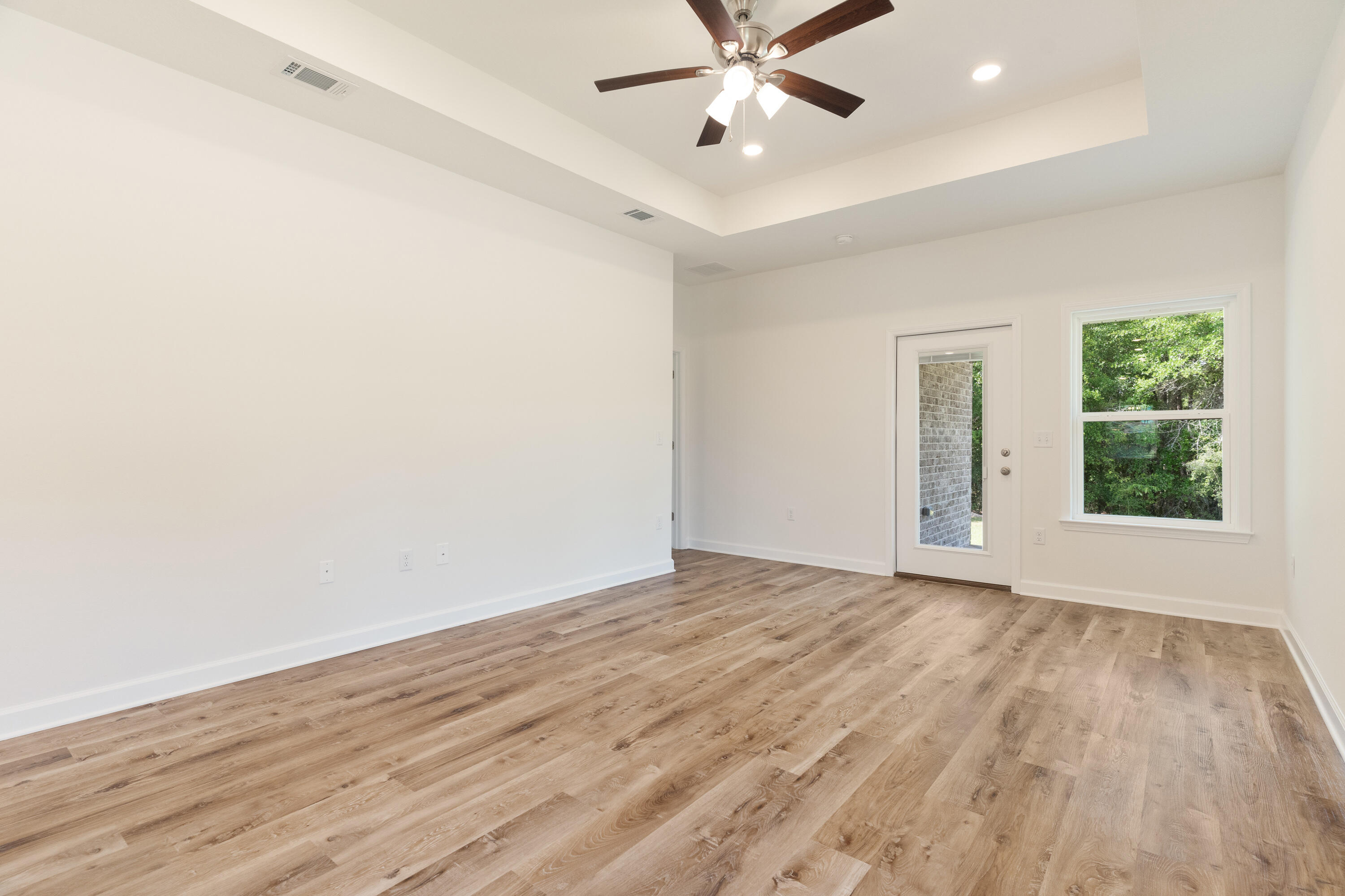 3202 Oxmore Drive Crestview, FL 32539 - Photo 10 of 20 an empty room with wooden floor fan and windows