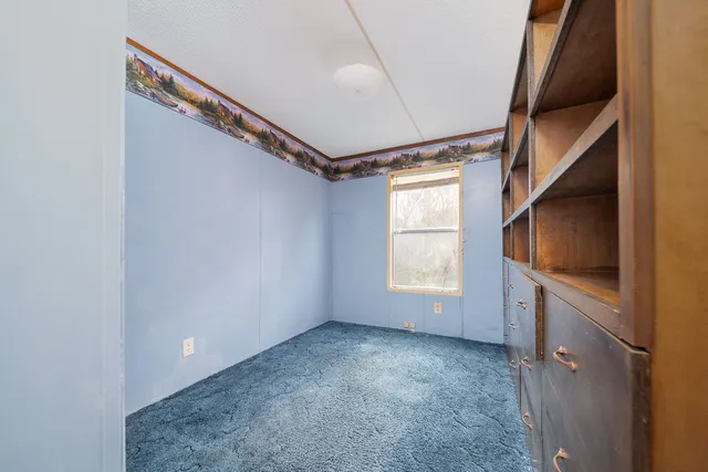 a view of empty room with window and fireplace