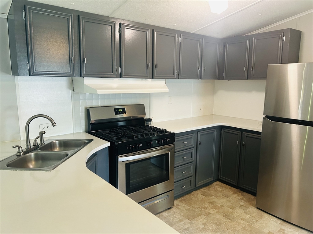 735 Memorial Drive, Unit 115 Chicopee, MA 01020 - Photo 3 of 8 a kitchen with a refrigerator stove and cabinets