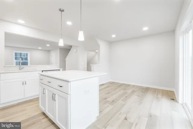 a kitchen with a refrigerator a stove top oven a sink and cabinets