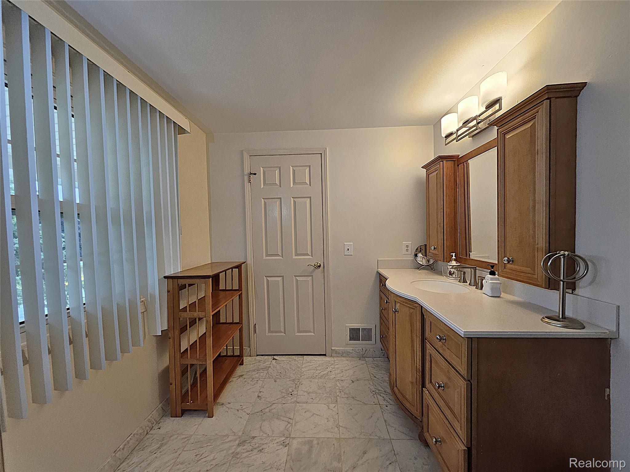 1114 Chaffer Drive Rochester, MI 48306 - Photo 44 of 50 Bathroom featuring a dual-sink vanity with light wood cabinetry, white countertops, and integrated storage