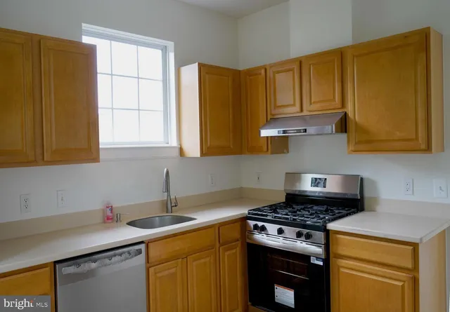 a kitchen with stainless steel appliances granite countertop a sink stove and cabinets