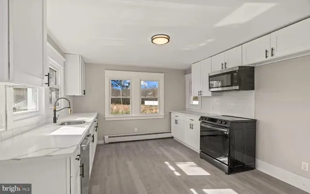 a kitchen with a sink stove top oven and refrigerator