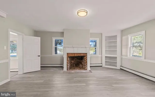 a view of a livingroom with a fireplace and window