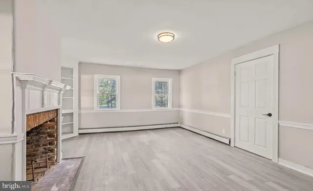 wooden floor in an empty room with a fireplace