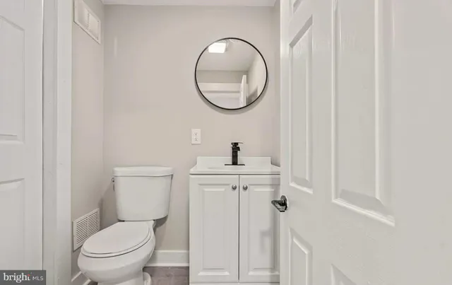 a bathroom with a toilet a sink and a mirror