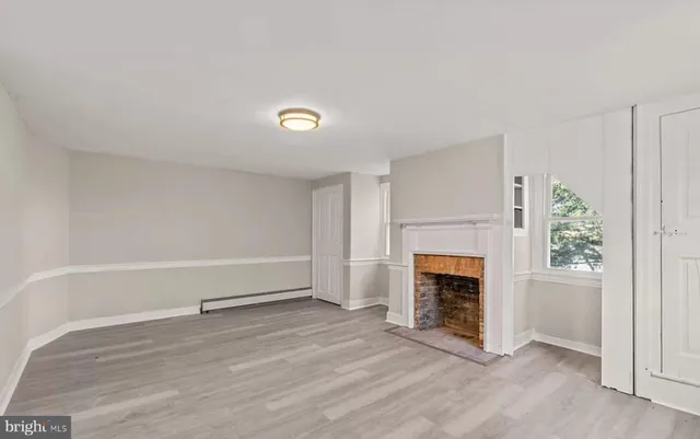 a view of an empty room with a fireplace and a window