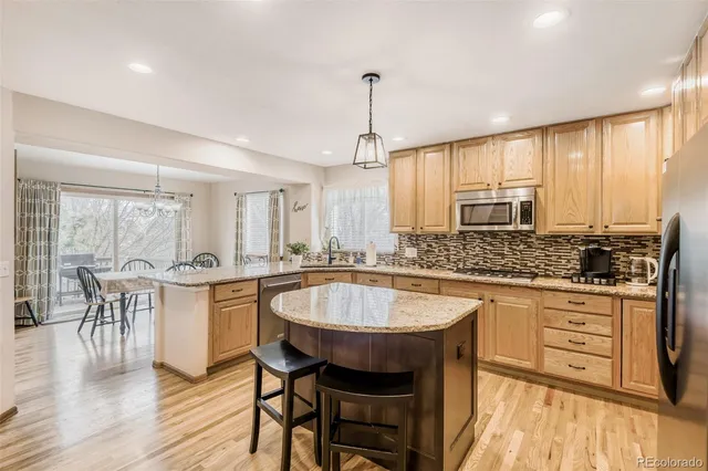 a large kitchen with kitchen island a sink table and chairs