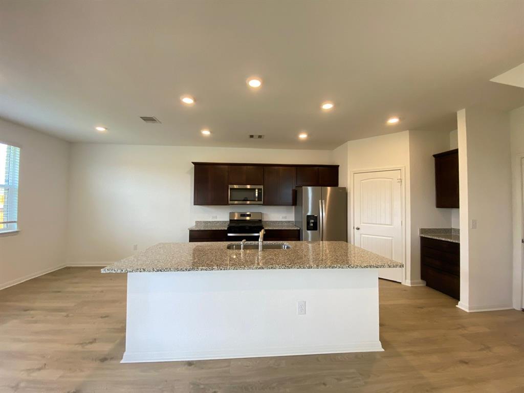 225 Saide Street Georgetown, TX 78626 - Photo 4 of 22 a large kitchen with stainless steel appliances a large counter top and a wooden floors