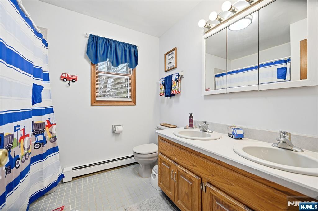 6 Robin Drive Oak Ridge, NJ 07438 - Photo 35 of 49 a bathroom with a sink a vanity and a mirror