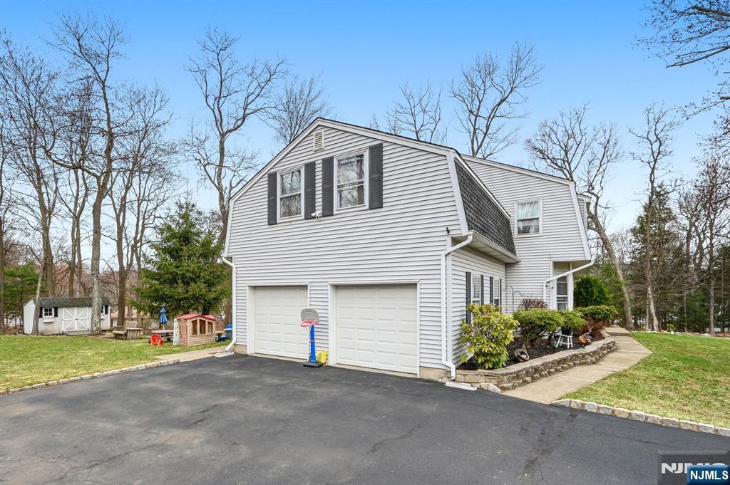 6 Robin Drive Oak Ridge, NJ 07438 - Photo 41 of 49 a front view of a house with a yard and garage