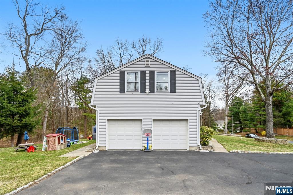 6 Robin Drive Oak Ridge, NJ 07438 - Photo 42 of 49 a front view of a house with a yard and garage