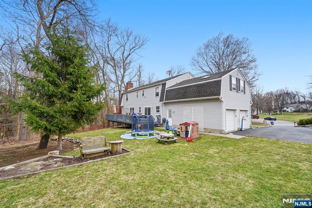 6 Robin Drive Oak Ridge, NJ 07438 - Photo 43 of 49 a backyard of a house with garden and outdoor seating