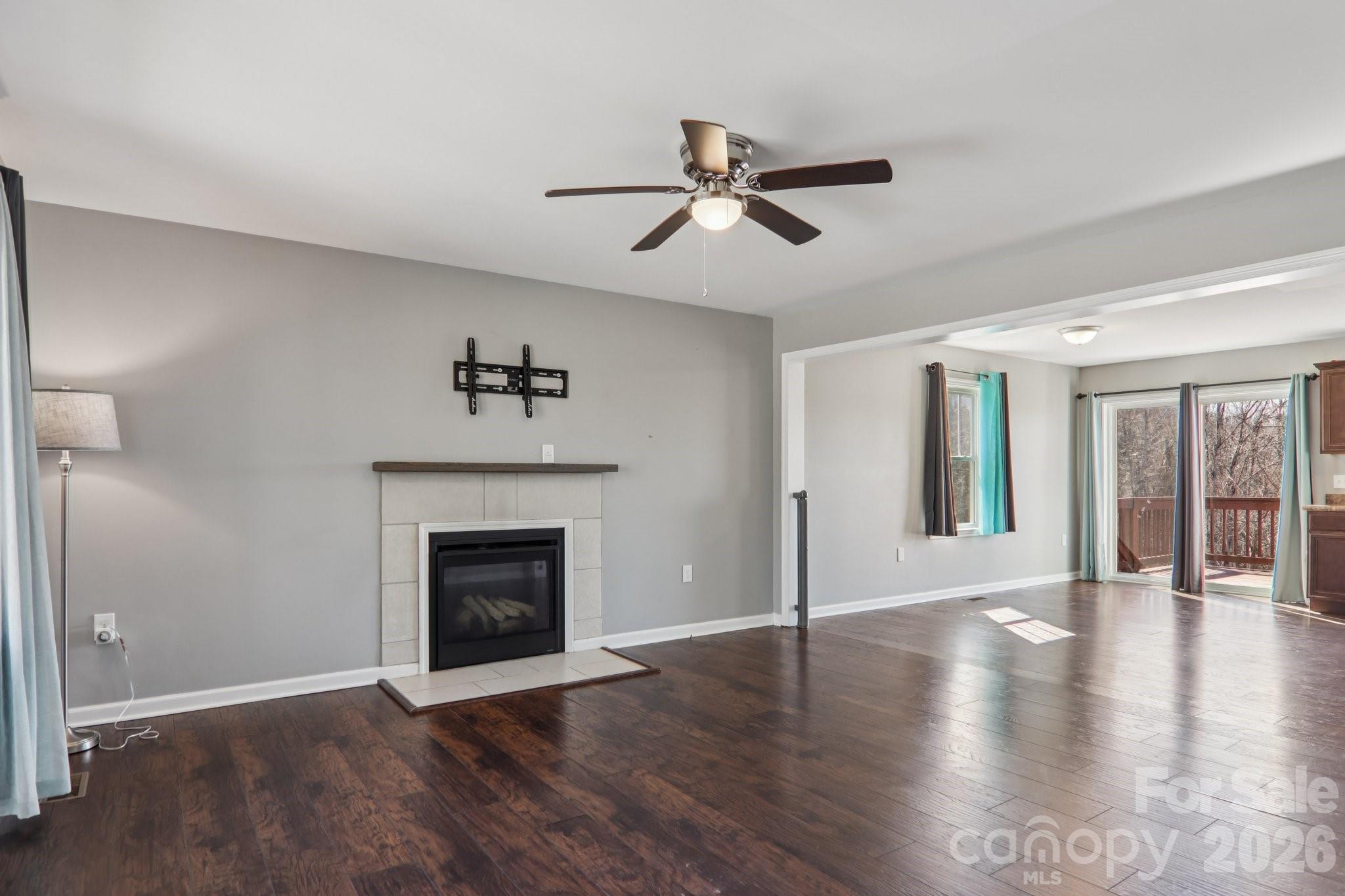751 Hutch Mountain Road Fletcher, NC 28732 - Photo 11 of 48 a view of an empty room with wooden floor fireplace and a window