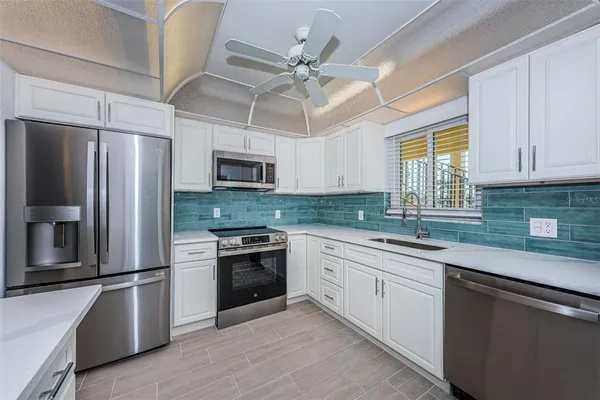 a kitchen with stainless steel appliances a stove sink and microwave
