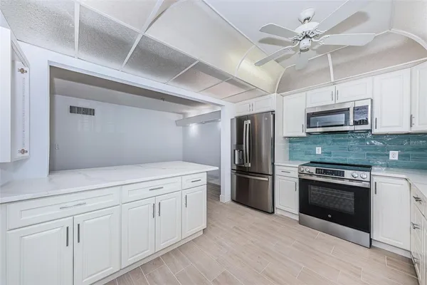 a kitchen with granite countertop cabinets stainless steel appliances a sink and a window