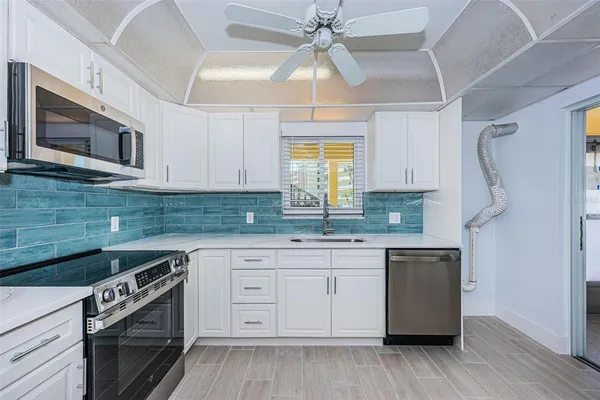 a large white kitchen with a large window
