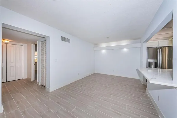 an empty room with wooden floor and chandelier fan