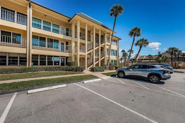 a front view of a house with palm trees