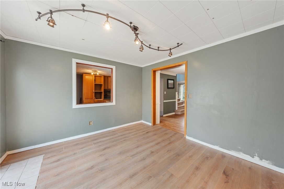 4146 Wyncote Road South Euclid, OH 44121 - Photo 11 of 20 Empty room featuring baseboards, ornamental molding, wood finished floors, and rail lighting