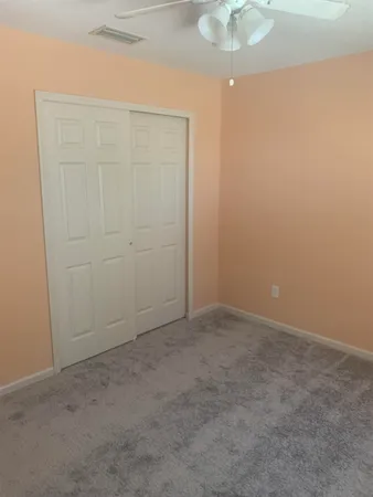 an empty room with a chandelier fan