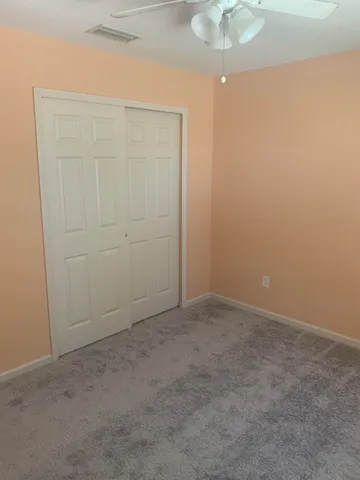 an empty room with a chandelier fan