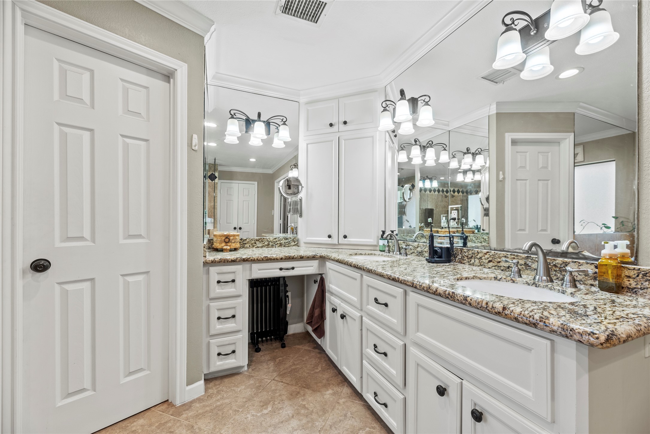 1203 Lemm Road 2 Spring, TX 77373 - Photo 11 of 21 The spacious primary bath features a long granite vanity with double sinks and a dedicated vanity area for a makeup or dressing station. Bright lighting and extensive mirror space complement the white cabinetry, creating a functional and open atmosphere.