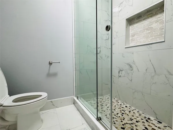 a bathroom with a toilet and shower