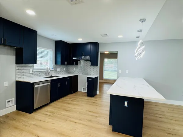 a large kitchen with stainless steel appliances kitchen island granite countertop a stove a sink and a refrigerator