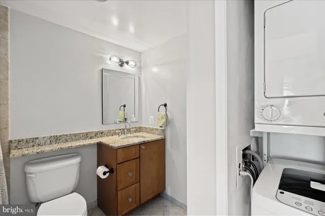 a bathroom with a granite countertop toilet sink and mirror