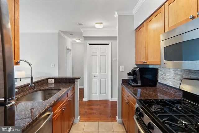 a kitchen with a sink stove top oven and cabinets