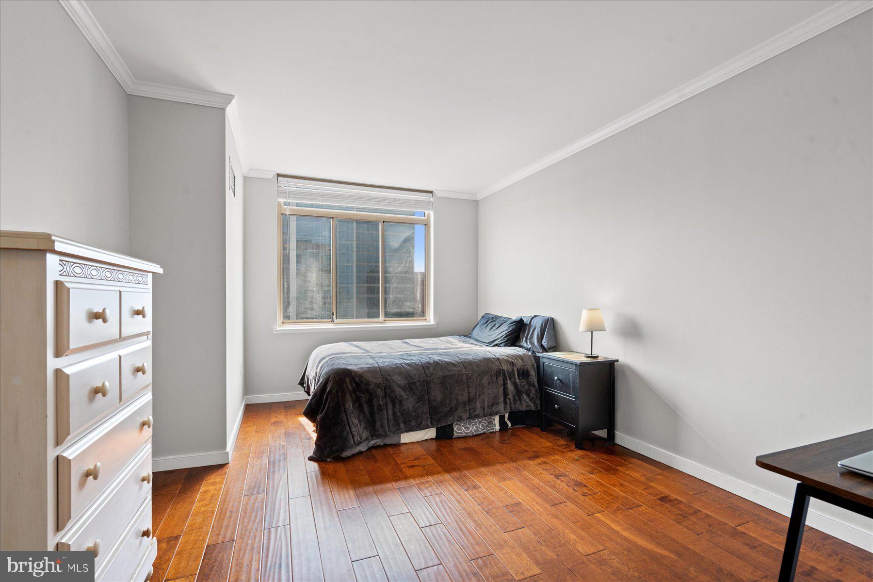 4801 Fairmont Avenue, Unit 705 Bethesda, MD 20814 - Photo 10 of 19 a bedroom with a bed and wooden floor