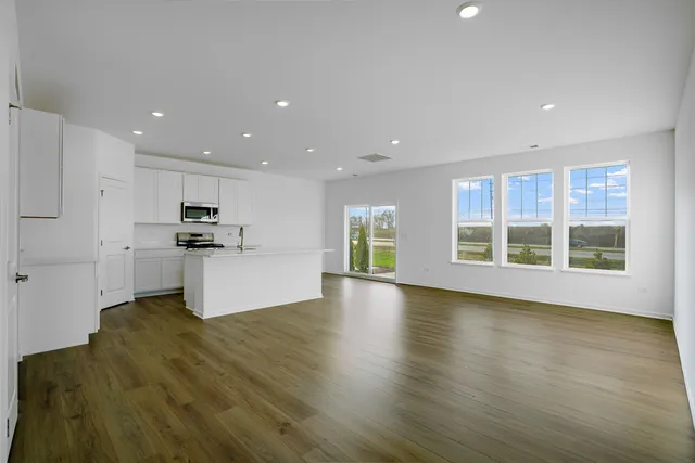a view of kitchen with stove and white cabinets