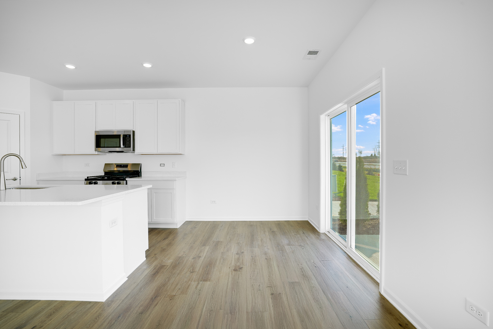 359 Red Oak Circle Volo, IL 60020 - Photo 7 of 18 a kitchen with a sink a microwave a window and wooden floor