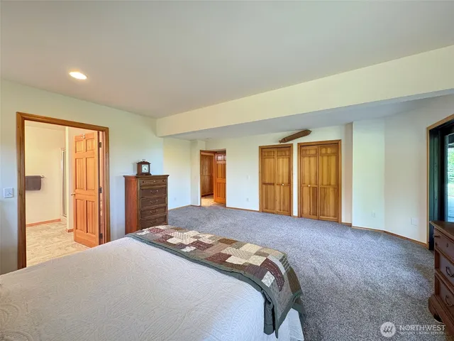 a bedroom with a bed and dresser with mirror