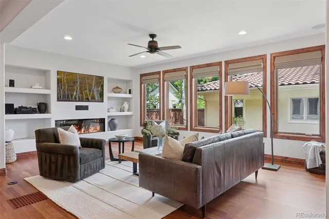 a living room with furniture flat screen tv and large windows