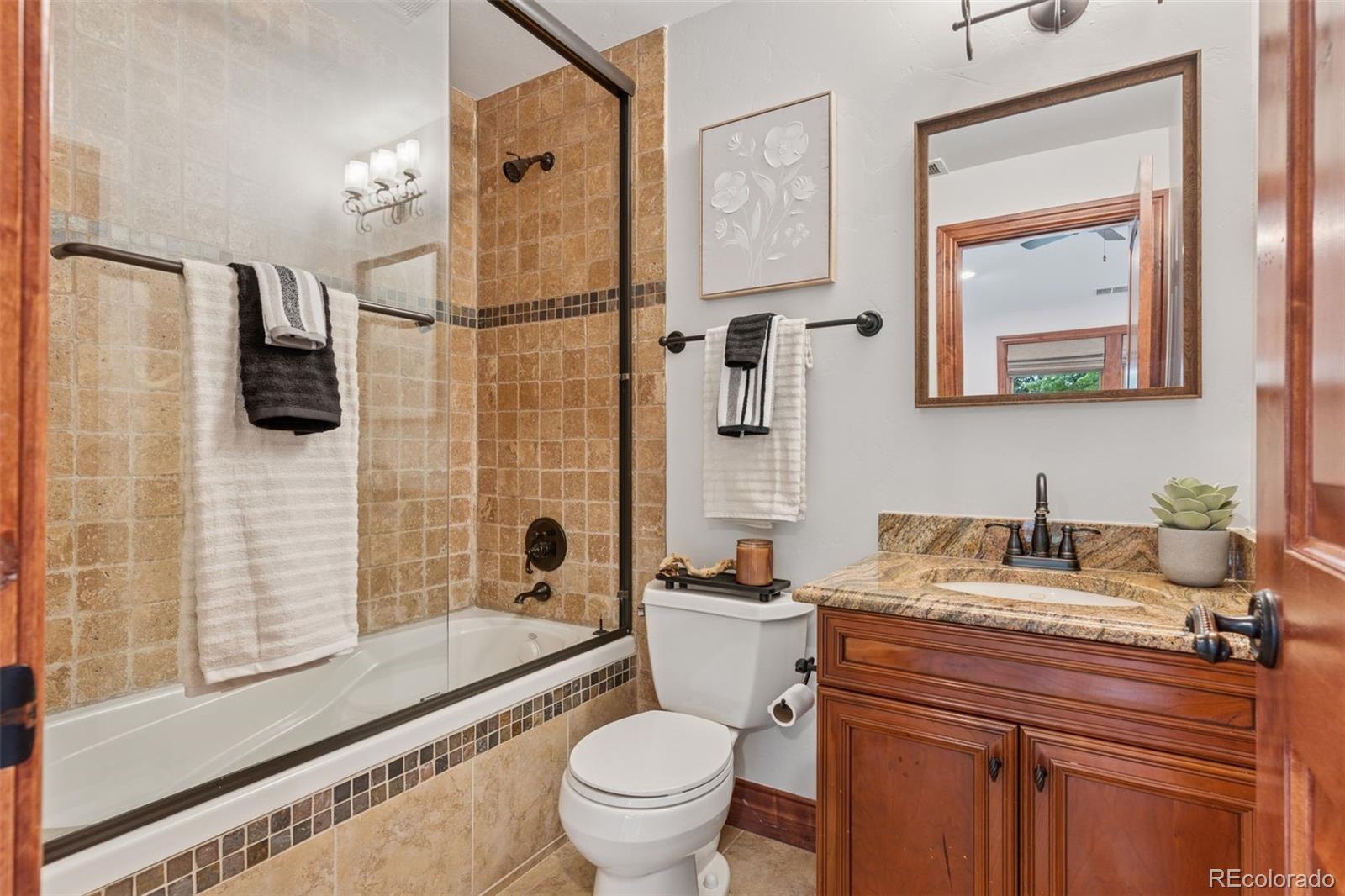 1026 South Cook Street Denver, CO 80209 - Photo 26 of 41 a bathroom with a granite countertop sink toilet and shower