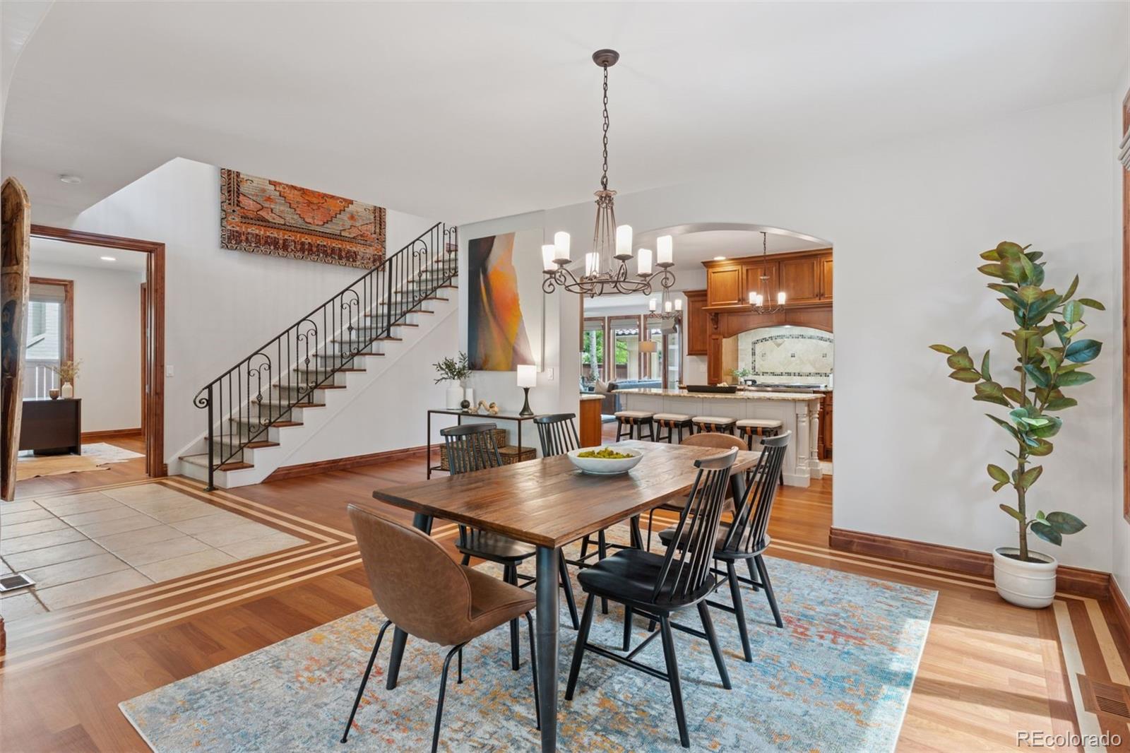 1026 South Cook Street Denver, CO 80209 - Photo 8 of 39 a view of a dining room and livingroom with furniture wooden floor a chandelier