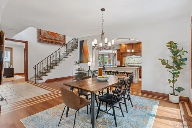 a view of a dining room and livingroom with furniture wooden floor a chandelier