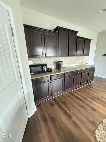 a kitchen with granite countertop a sink and cabinets