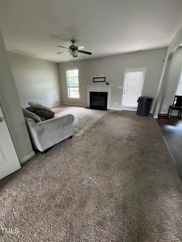 an empty room with windows and ceiling fan