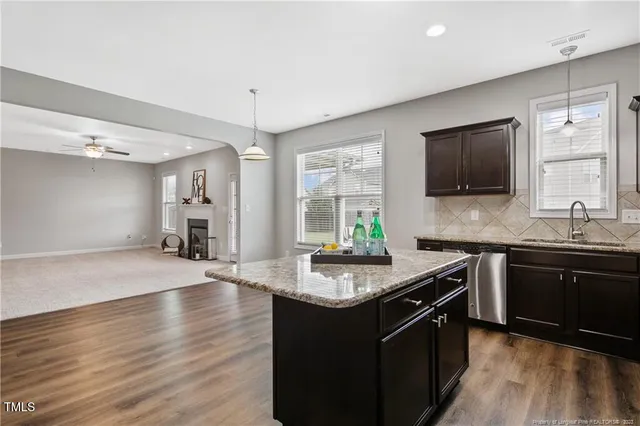 a kitchen with stainless steel appliances granite countertop a sink stove and wooden floor